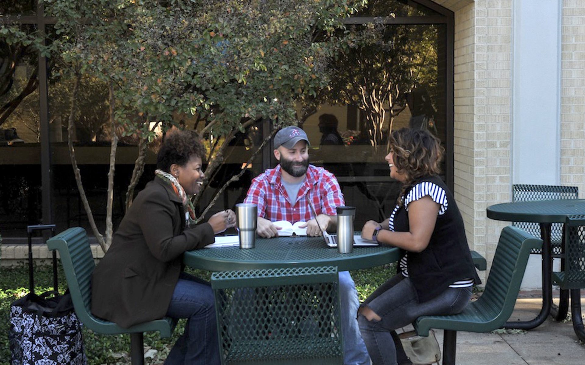 students sitting at a table in front of Walvoord Hall