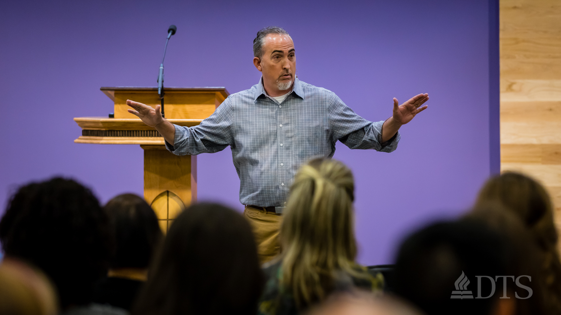 Dr. Mark Yarbrough standing in front of podium while speaking at DTS Chapel
